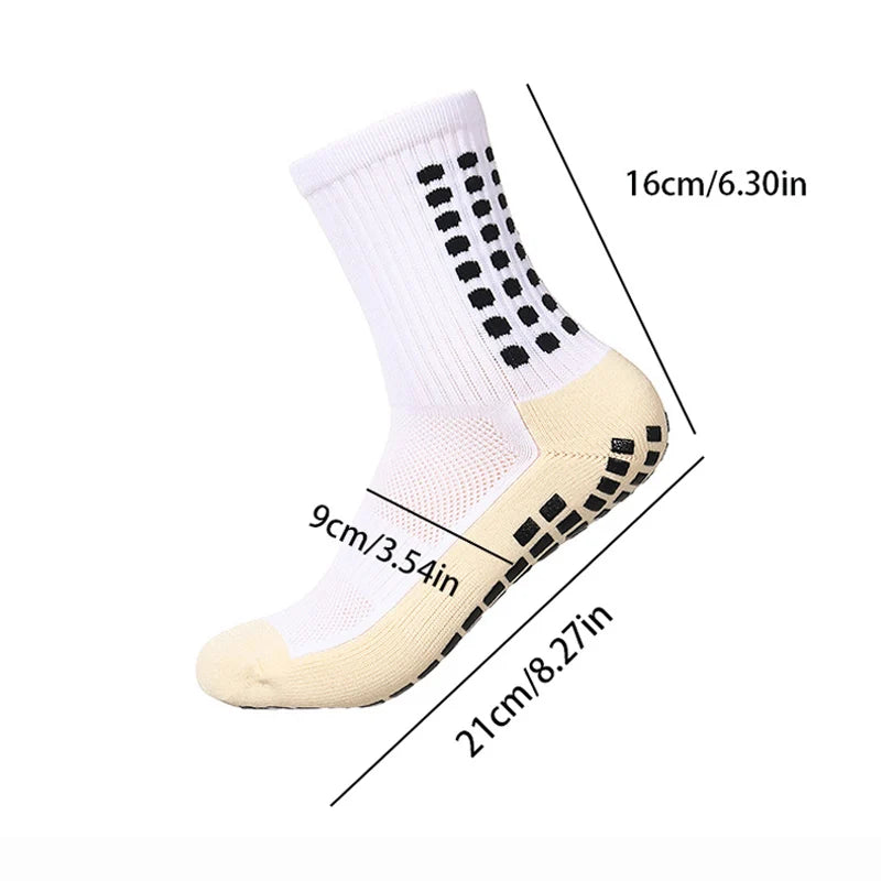 A pair of white sports socks with black dots and a beige sole, shown from the side.