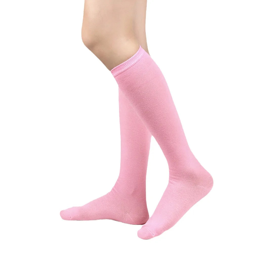 Un par de calcetines altos rosas sólidos puestos en una pierna.