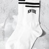 White crew socks with black stripes and the text NEW YORK on the calf.