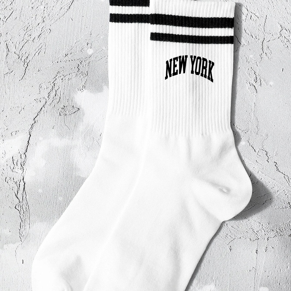 White crew socks with black stripes and the text NEW YORK on the calf.