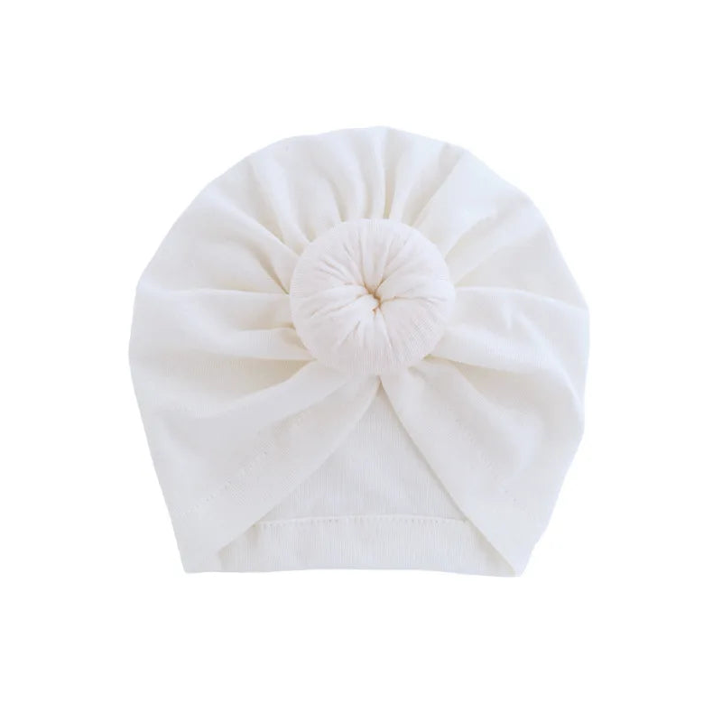 Weißer Baumwoll-Baby-Turban, gefaltet in eine Rosette.
