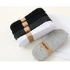 A stack of multi-colored breathable cotton ankle socks, including black and white pairs, are displayed on a white background.