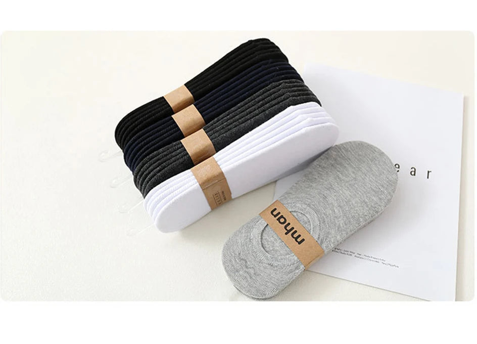 A stack of multi-colored breathable cotton ankle socks, including black and white pairs, are displayed on a white background.