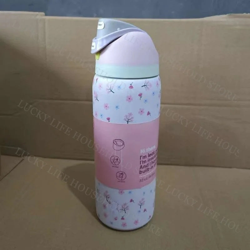 A pink insulated stainless steel sports water bottle with a light green cap and floral patterns.