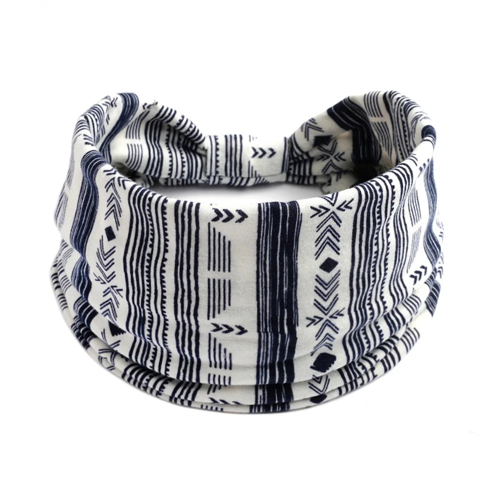 A close-up of a black and white striped bohemian cotton stretch headband rolled up.