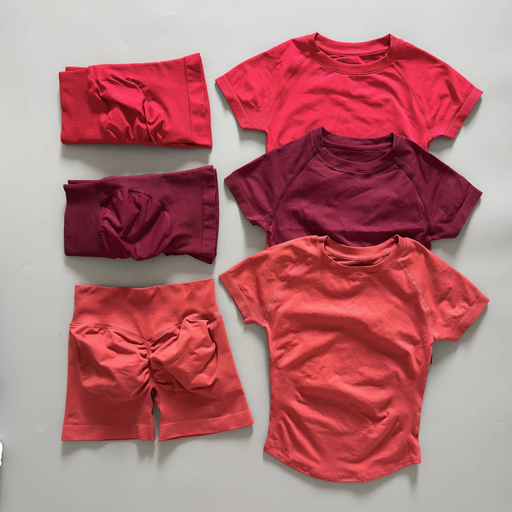 Un ensemble de tenues de yoga et de sport (hauts et bas) sans coutures dans différentes nuances de rouge et de marron foncé.