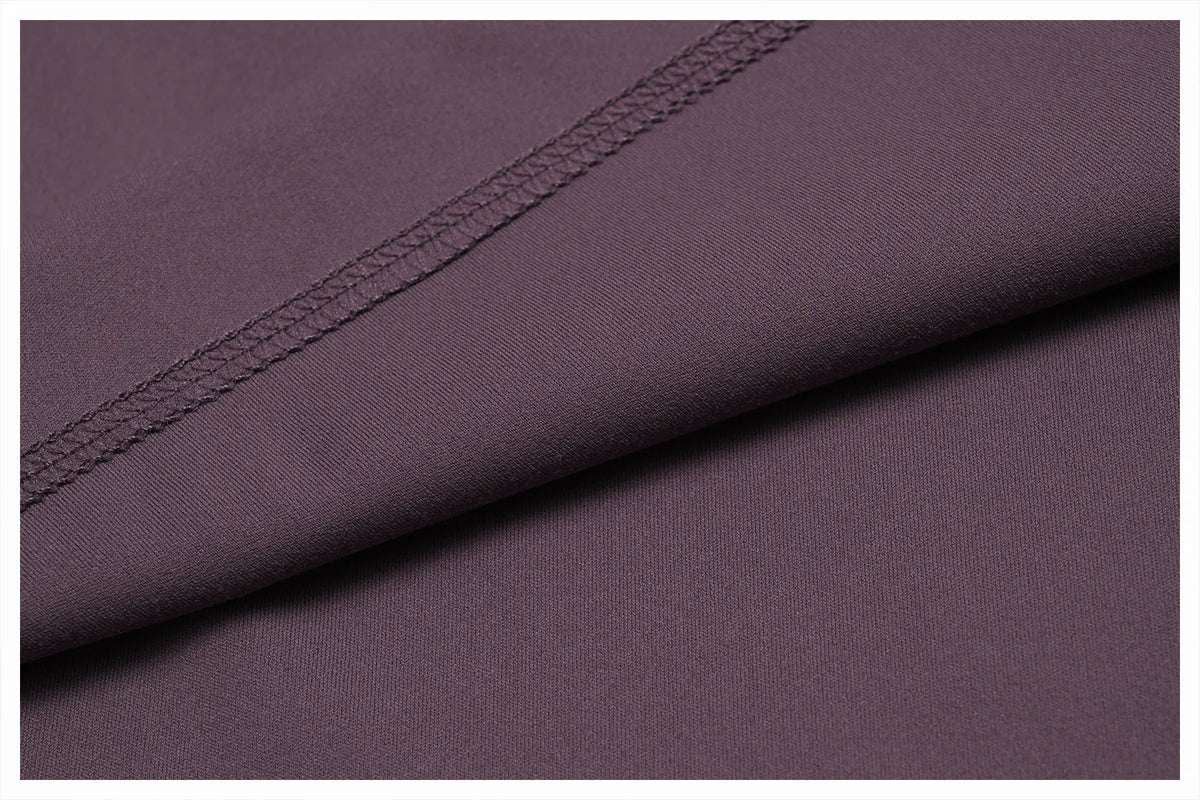 Close-up of a mauve women's high-waist flared yoga pant fabric with a stitched seam detail.