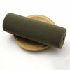 A roll of olive green elastic bands resting on a wooden surface.