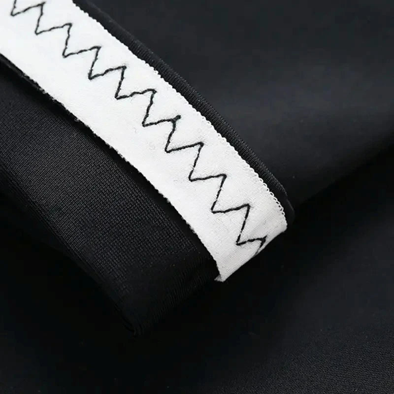 Close-up of a white, zigzag patterned sport arm sleeve on a black fabric background.