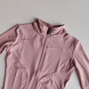 A light pink quick-dry yoga and fitness jacket with a full zip collar shown from the chest up.