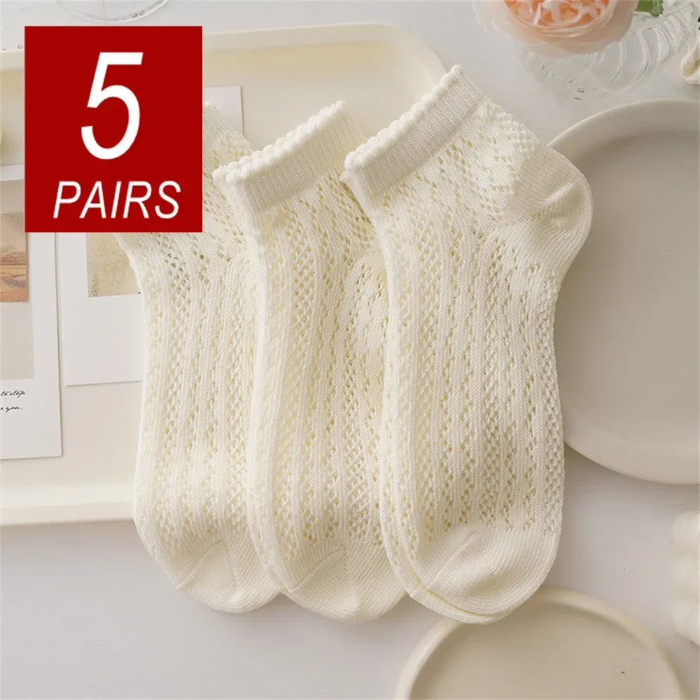 Five pairs of cream colored breathable mesh lace tube socks displayed on a white surface.