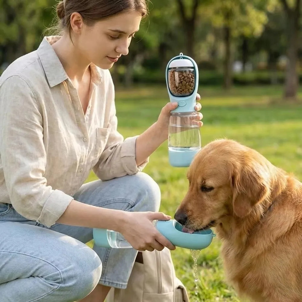 A woman feeds a dog using a 3-in-1 portable pet water and food dispenser.