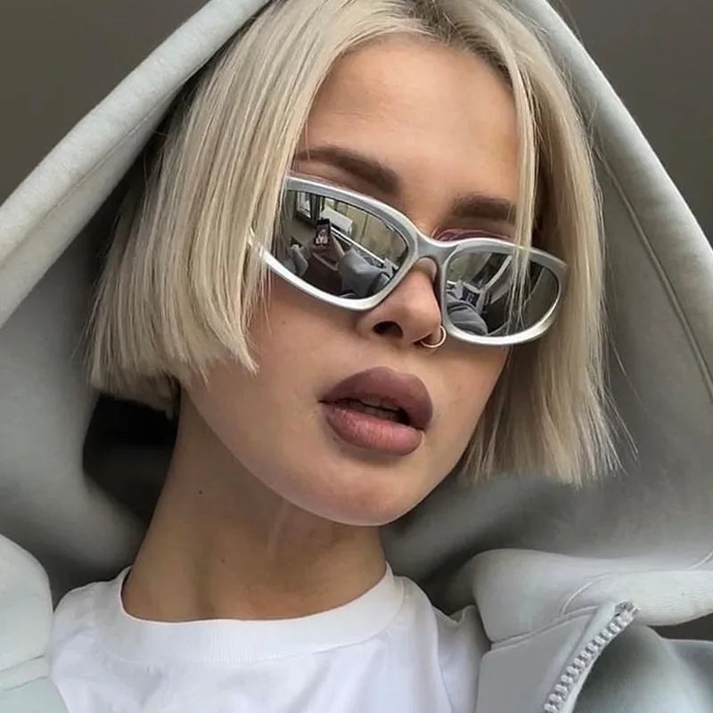 A woman wearing vintage rectangle aviator sunglasses indoors