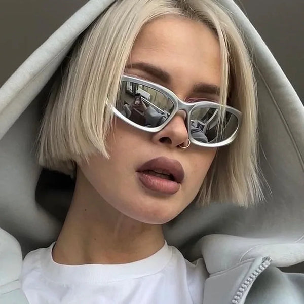 A woman wearing vintage rectangle aviator sunglasses indoors