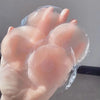 Une main tient un ensemble de cache-lèvres en silicone réutilisables, clairs et ronds.