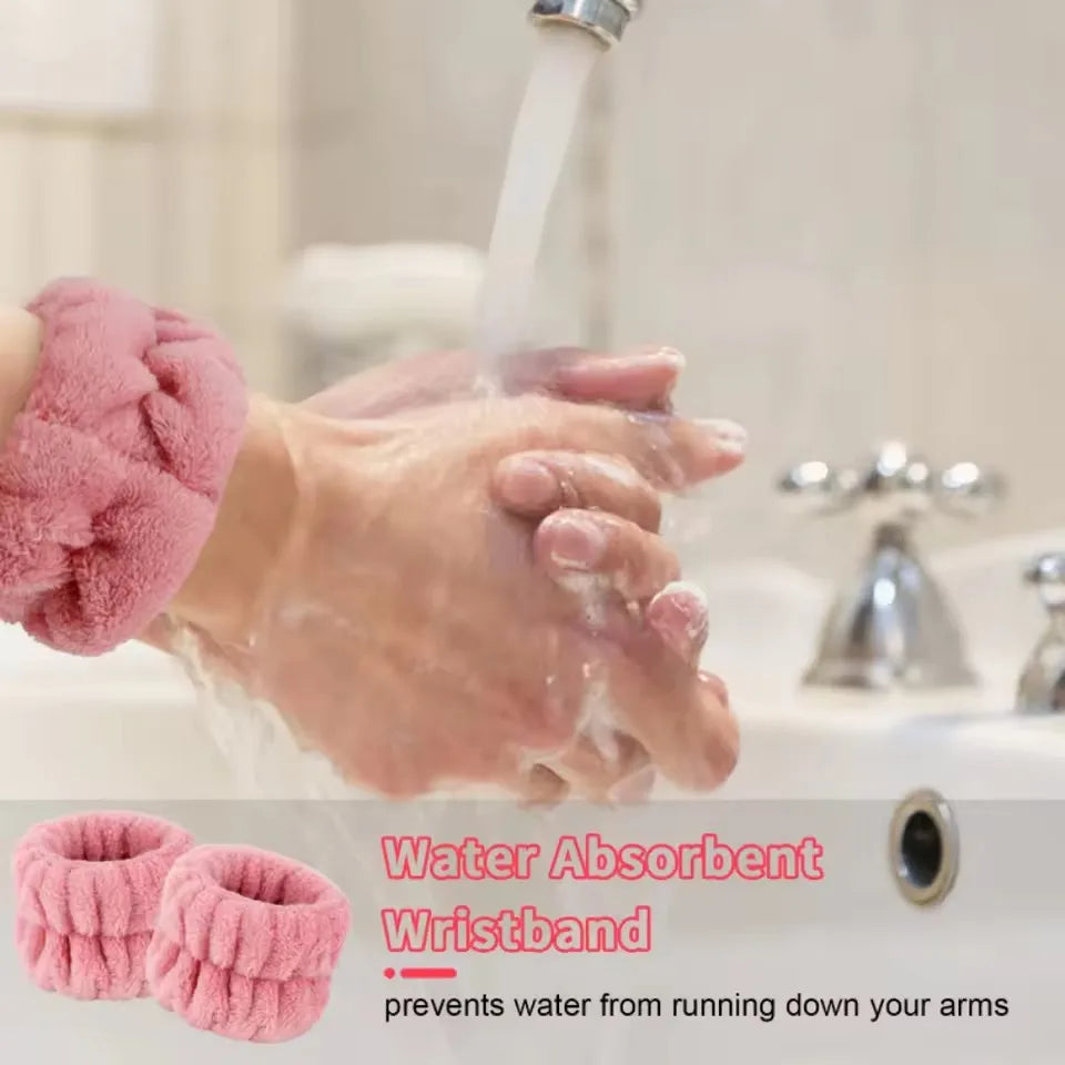 A pair of pink water absorbent wristbands being used under running water.