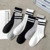 A pack of ten cotton striped breathable sport socks in black, white, and gray are laid out on a light surface.