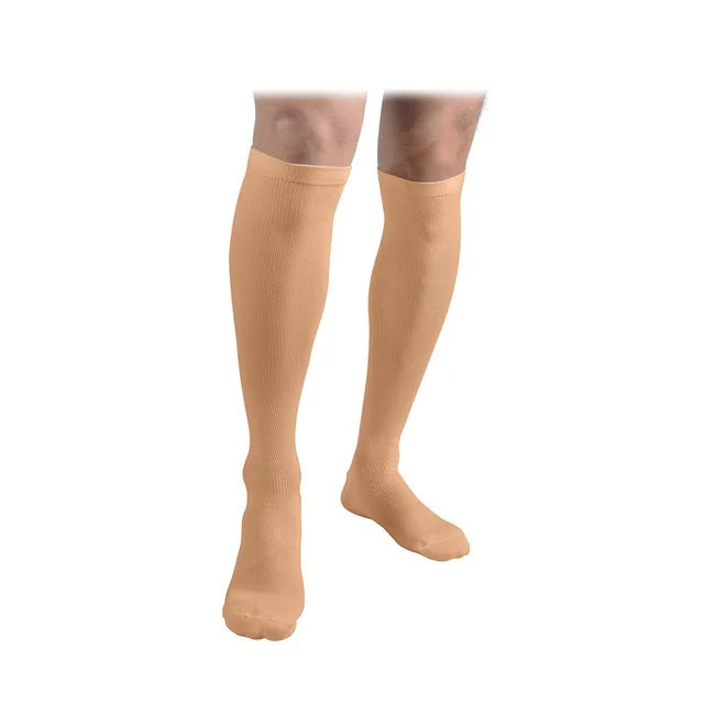 A pair of tan compression socks worn on a person's lower leg.