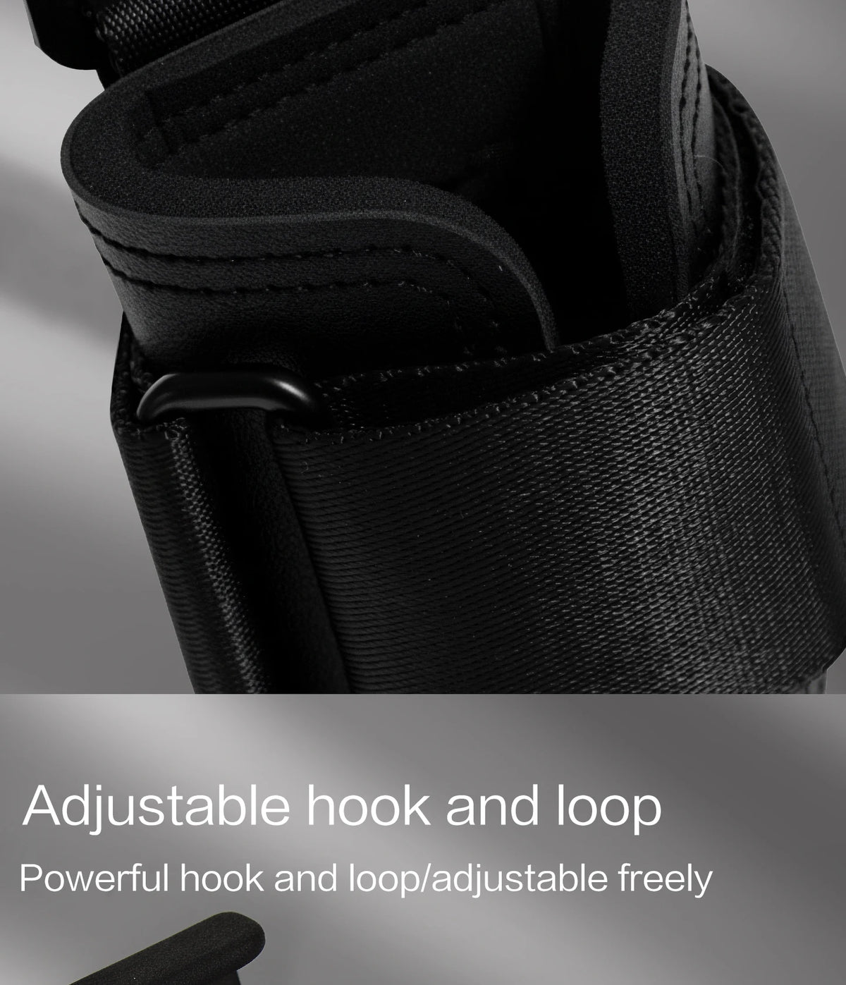 Close-up of black adjustable hook and loop strap used for wrist wraps or lifting gear.