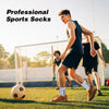 Ein junger Mann mit sportlichen Socken rennt auf einem Fußballfeld mit einem Fußball.