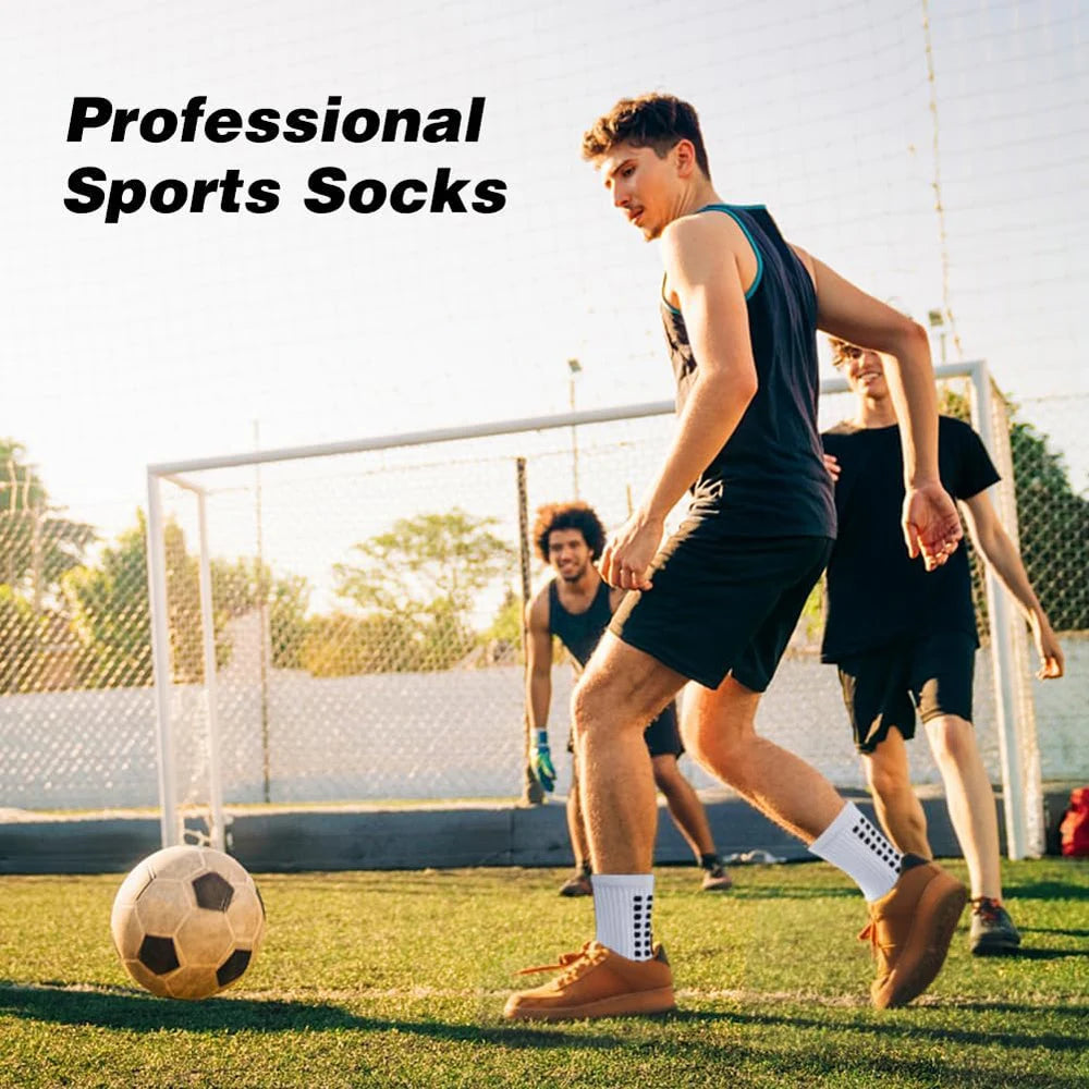 Ein junger Mann mit sportlichen Socken rennt auf einem Fußballfeld mit einem Fußball.