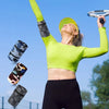 A woman wearing a neon green sports top holds up a clear plastic wrist bag with a silver rim against a blue sky.