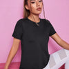 A woman models a black breathable summer yoga and fitness t-shirt while sitting down.