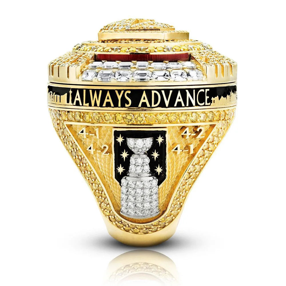 A close-up of a gold championship ring featuring diamonds and engraved text.