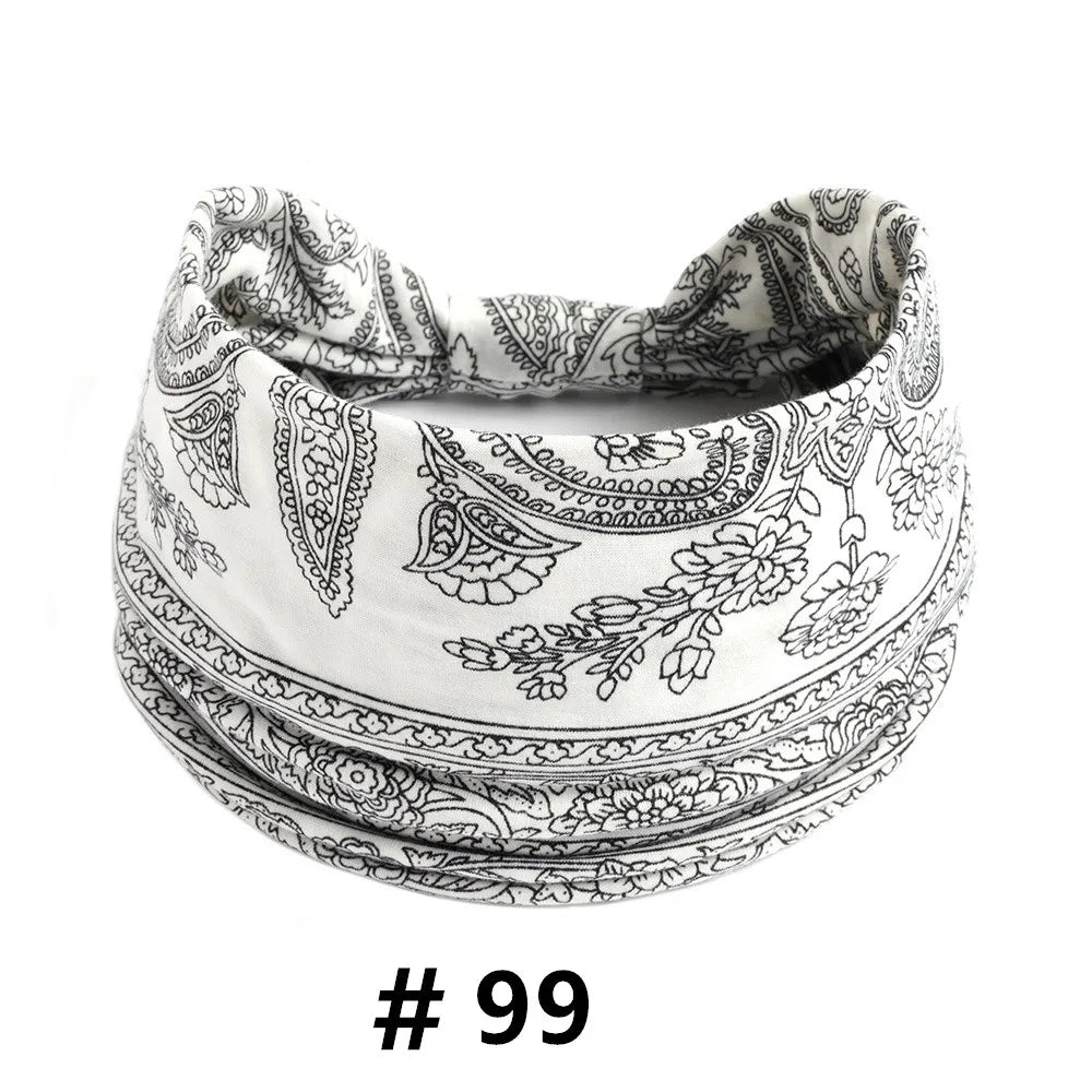 A close-up of a white cotton boho print headband folded and displayed.