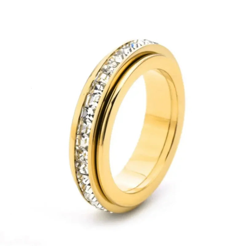 A close-up view of a gold-toned statement ring featuring a pave setting of clear cubic zirconia stones.