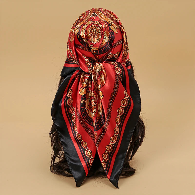 A red and black satin square scarf tied around dark hair