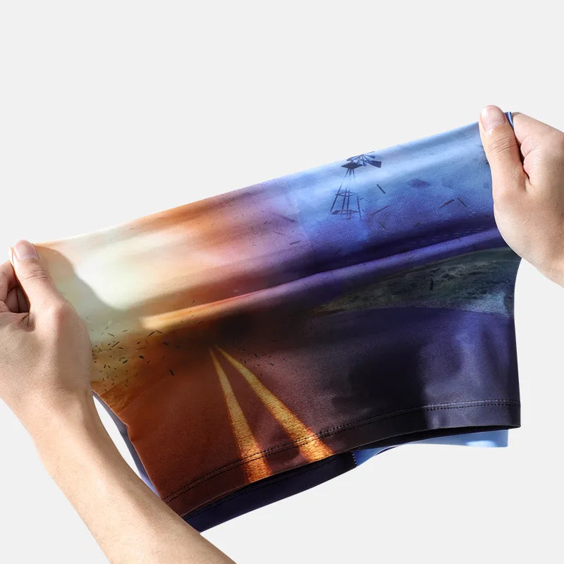 A hand holds up a dark blue arm sleeve featuring an orange and yellow gradient design.
