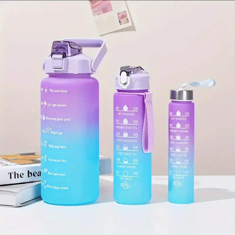 Un juego de tres botellas deportivas de agua con degradado morado y azul y pajitas sobre una superficie blanca.