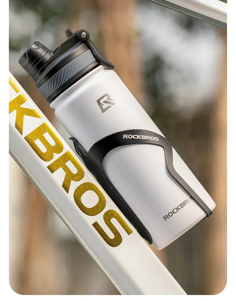 A white insulated stainless steel thermal water bottle with a black cap is shown next to a yellow and black branded item.