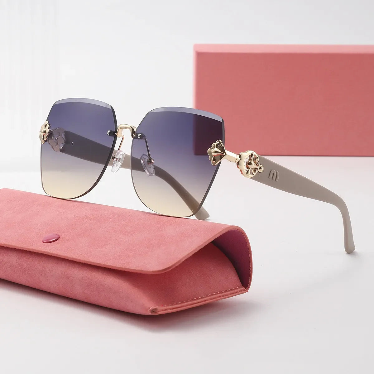 A pair of light brown framed sunglasses resting on a pink velvet pouch.