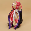 A vibrant pink and gold floral satin square scarf tied around a dark hair, featuring purple trim.