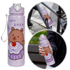 A cute purple capybara water bottle with a straw and handle is shown next to a bicycle wheel.