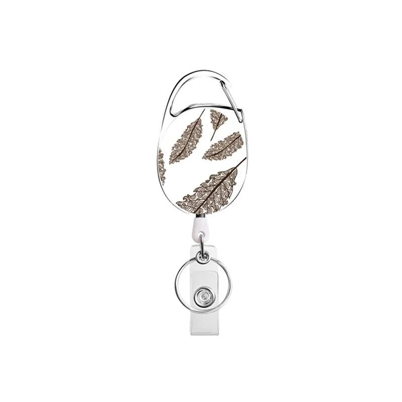 A silver retractable ID badge reel keychain featuring a leaf design.