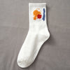 A white sock with orange and blue paint splatters on the top, displayed against a gray background.