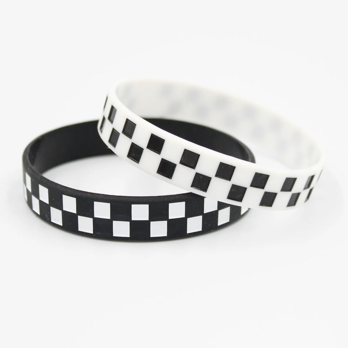 A black and white checkered silicone wristband shown in a stack on a white background.