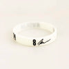 A white silicone wristband with black text showing the number 8 and a signature.
