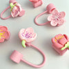 Pink silicone straw covers shaped like flowers for tumblers and water bottles
