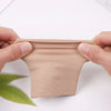 Une main tient un manchon de compression beige, montrant sa texture et son ajustement.