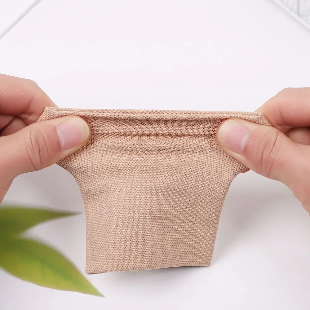 Une main tient un manchon de compression beige, montrant sa texture et son ajustement.