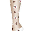 A close-up view of beige compression socks with small heart patterns and white tips.