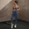 Eine Frau modelliert ein navyblaues Sport-BH und Leggingsset mit Kontrastrand gegen einen neutralen Hintergrund.