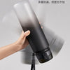 A hand is holding a black sports water bottle, demonstrating its stability and durability.