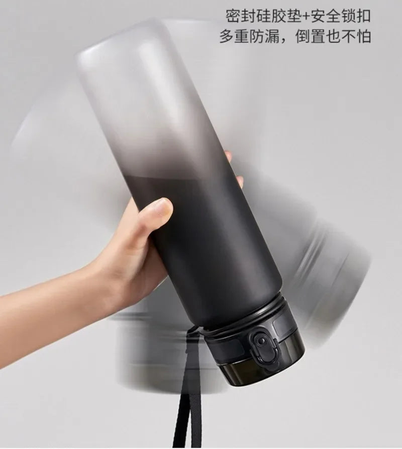 A hand is holding a black sports water bottle, demonstrating its stability and durability.
