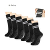Six pairs of black grip socks with white stripes shown for yoga and barre