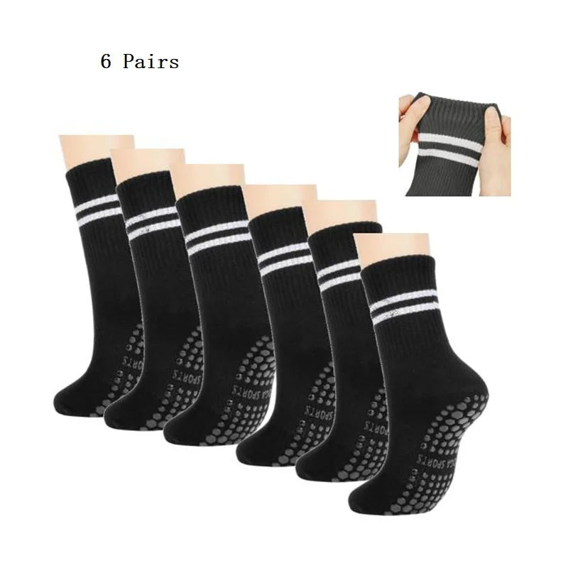 Six pairs of black grip socks with white stripes shown for yoga and barre